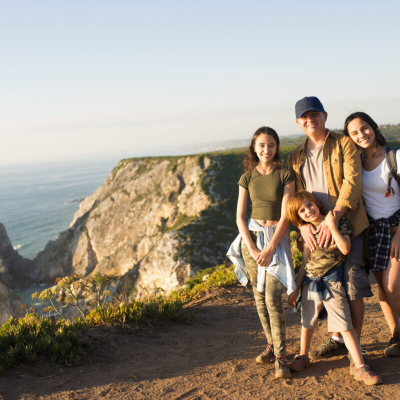 happy father hiking with children in mountains